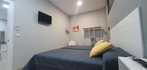a bedroom with a bed with a yellow pillow at Apartamentos Las trece llaves in Mérida