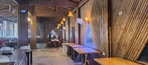 a room with wooden walls and tables in a restaurant at BAGIYA Hut RESORT in Billi