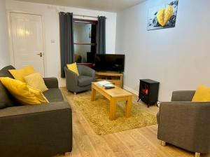 a living room with two couches and a coffee table at Rendezvous , Aviemore in Aviemore