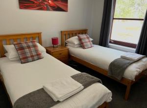 a bedroom with two beds and a window with at Rendezvous , Aviemore in Aviemore