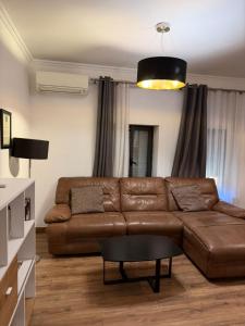 a living room with a brown leather couch and a table at Hotel La Cita in Tirana