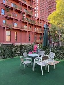 a patio with a table and chairs and an umbrella at Hotel La Cita in Tirana