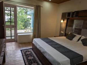 a bedroom with a large bed and a window at Deodar hill top home stay chail in Chail
