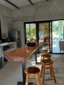 a large wooden table with stools in a room at Sansalo Lounge Capira in Lídice