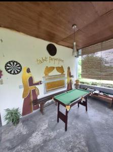 a ping pong table in a room with a wall mural at Talaga Tomohon Home Stay and Fishing Pond in Tomohon