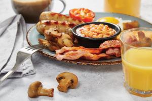 a plate of food with seafood and beans and a glass of orange juice at Bull Hotel by Greene King Inns in Halstead +24 photos