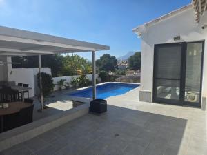 a house with a swimming pool and a patio at Villa Good Vibes in Ifach