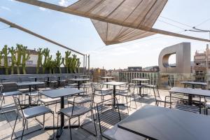 a patio with tables and chairs on a roof at B Hotel in Barcelona