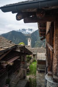 a view of an village with a church in the distance at Walser House in Rimella