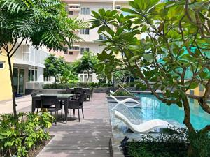 a resort with a pool and tables and trees at 3ff Megaworld, One Regis in Bacolod