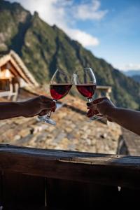 two people holding up glasses of red wine at Walser House in Rimella