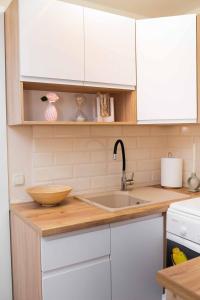 a kitchen with white cabinets and a wooden counter top at Гостьовий будинок для відпочинку в Nesterivka Family Park in Boryspil