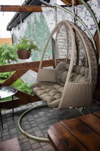 a wicker swing chair sitting on a patio at Гостьовий будинок для відпочинку в Nesterivka Family Park in Boryspil