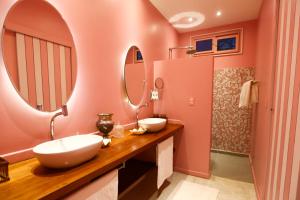 a bathroom with two sinks and two mirrors at Vila Stella Cadente in Fortim +26 photos
