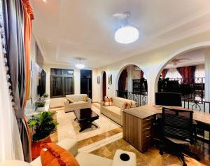 a large living room with a table and a desk at 3R Haven in Kumasi