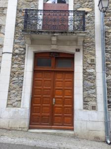 a wooden door on a building with a balcony at Appartement calme in Eaux-Bonnes