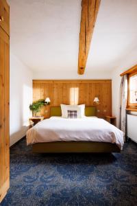 a bedroom with a large bed and a blue carpet at Hotel Chesa Rosatsch - Home of Food in Celerina