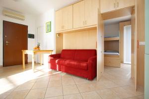 a red couch in a room with a bunk bed at WI-RO Cavour, 48 - Tra Cielo e Mare in Marina di Andora
