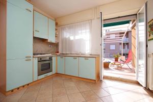 a kitchen with white cabinets and a large window at WI-RO Cavour, 48 - Tra Cielo e Mare in Marina di Andora