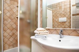 a bathroom with a sink and a mirror and towels at WI-RO Cavour, 48 - Tra Cielo e Mare in Marina di Andora +10 photos