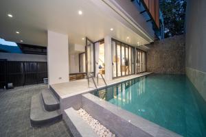 an indoor swimming pool in a house at 竹光别院 Bamboo Radiance Villa in Ban Thalat Choeng Thale