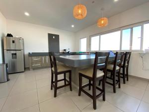 a kitchen with a table and chairs and a refrigerator at Casa Veleros, Casa a la orilla de la playa! in Ciudad Madero