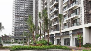 an apartment building with palm trees in front of it at Sky House BSD Apartment by Casanova in Cilenggang