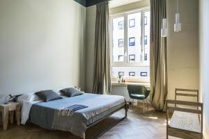 a bedroom with a bed and a large window at casaBASE in Milan