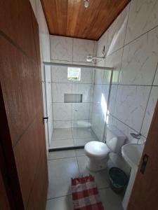 a small bathroom with a toilet and a sink at Lago Camping Sana in Macaé