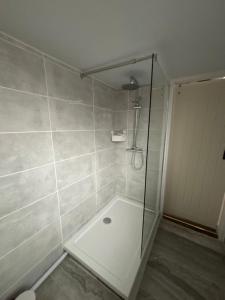 a shower with a glass door in a bathroom at The old surgery in Rhymney +11 photos