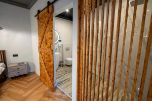 a bathroom with a sliding barn door and a toilet at Barrique Garden - Breakfast & Restaurant - Old Town -Officially classified guesthouse in Braşov +130 photos