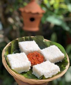 a bowl of tofu and sauce on a green leaf at Ceylon Bliss Retreat- Kandy Wellness Hotel in Kandy