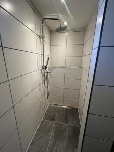a bathroom with a shower with white tile walls at Waldsee in Hilgert +10 photos
