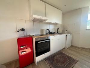a kitchen with a red refrigerator and white cabinets at Waldsee in Hilgert
