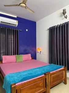 a bedroom with a bed with a blue wall at Sea lumina in Varkala
