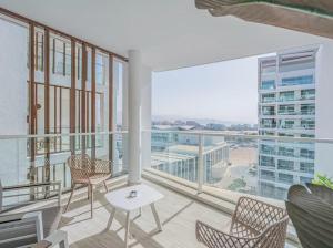 a balcony with chairs and a table and a large window at Redsearent suite with pool view 16 in Eilat