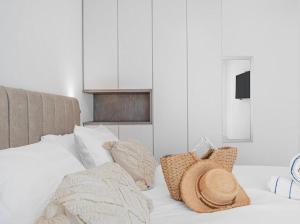 a white bed with pillows and a hat on it at Redsearent suite with pool view 16 in Eilat +9 photos