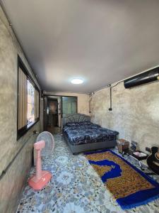 a bedroom with a bed and a rug at บ้านพักหลังวัดโลกโมฬี in Chiang Mai