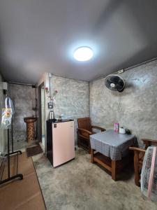 a small kitchen with a table and a refrigerator at บ้านพักหลังวัดโลกโมฬี in Chiang Mai