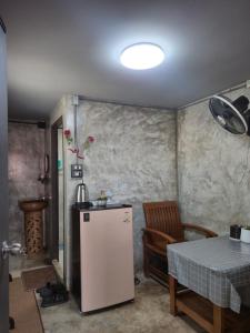 a small kitchen with a table and a refrigerator at บ้านพักหลังวัดโลกโมฬี in Chiang Mai +8 photos