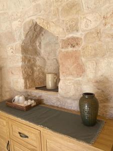 a stone wall with a counter with a vase and candles at Casina Fumarola in Ostuni +103 photos