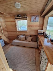 a small room with a couch in a log cabin at Mini saunahouse in Bašķi +96 photos