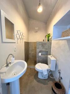 a bathroom with a white toilet and a sink at Pousada Jardim da Praça in Caraíva +44 photos