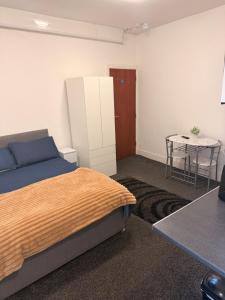 a bedroom with a bed and a table in it at Your Cozy Colne Getaway Free parking and views in Colne