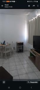 a living room with a tv and a table with a tableablish at no centro de Cuiabá aptº mobiliado in Cuiabá