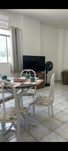 a dining table and chairs in a living room at no centro de Cuiabá aptº mobiliado in Cuiabá