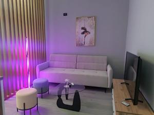 a living room with a pink couch and a table at My Daily Home in Fier
