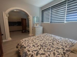 a bedroom with a bed and a dresser and windows at My Daily Home in Fier