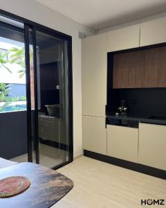 a bedroom with a kitchen with a view of the ocean at Homz Maison in Sukrah