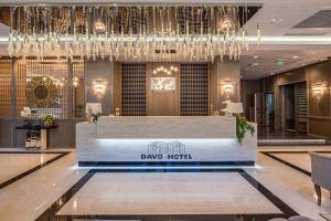 a hotel lobby with a reception desk and chandelier at Davo Hotel in Târgu Neamț